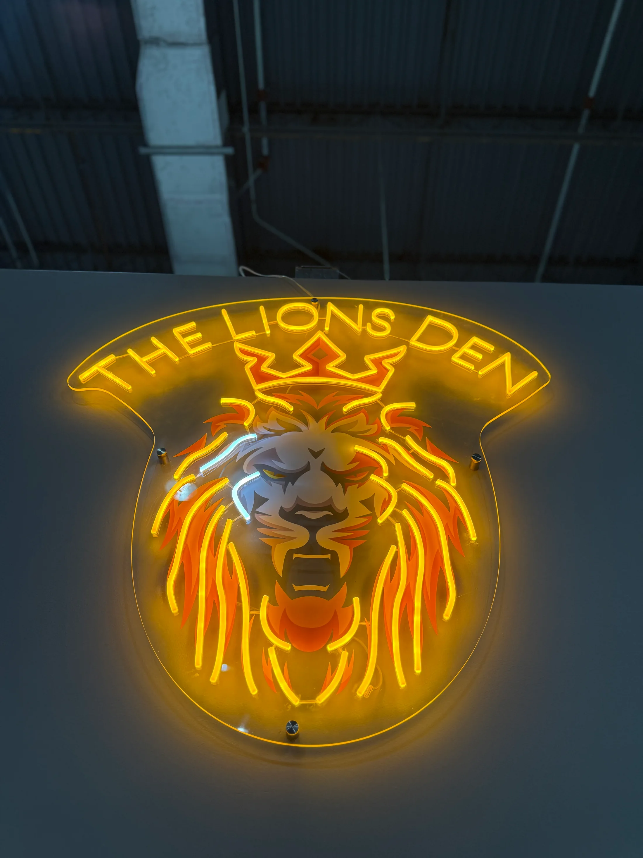 The illuminated Lions Den sign inside the private Boca Raton club